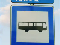 Zbliżenie na tabliczkę z nazwą przystanku i numerami linii