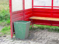 Kosz na śmieci przywiązany łańcuchem do ławki